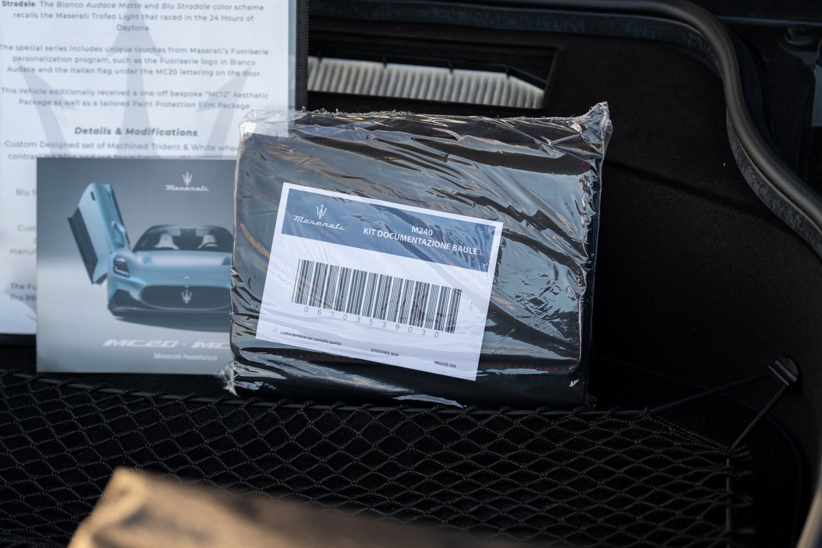 Maserati MC20 Icona in Blu Stradale with a car cover and documentation kit.