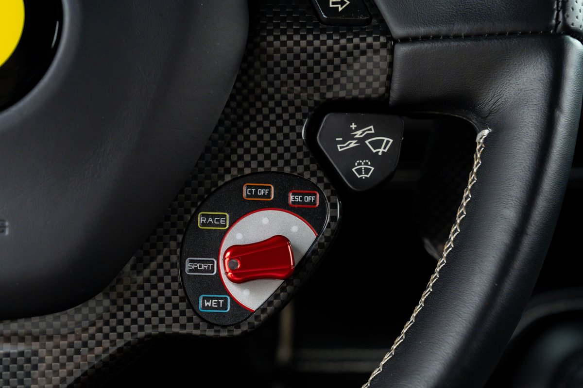 Carbon fiber trim on the 2015 Ferrari 458 Speciale steering wheel features driving mode selector buttons.