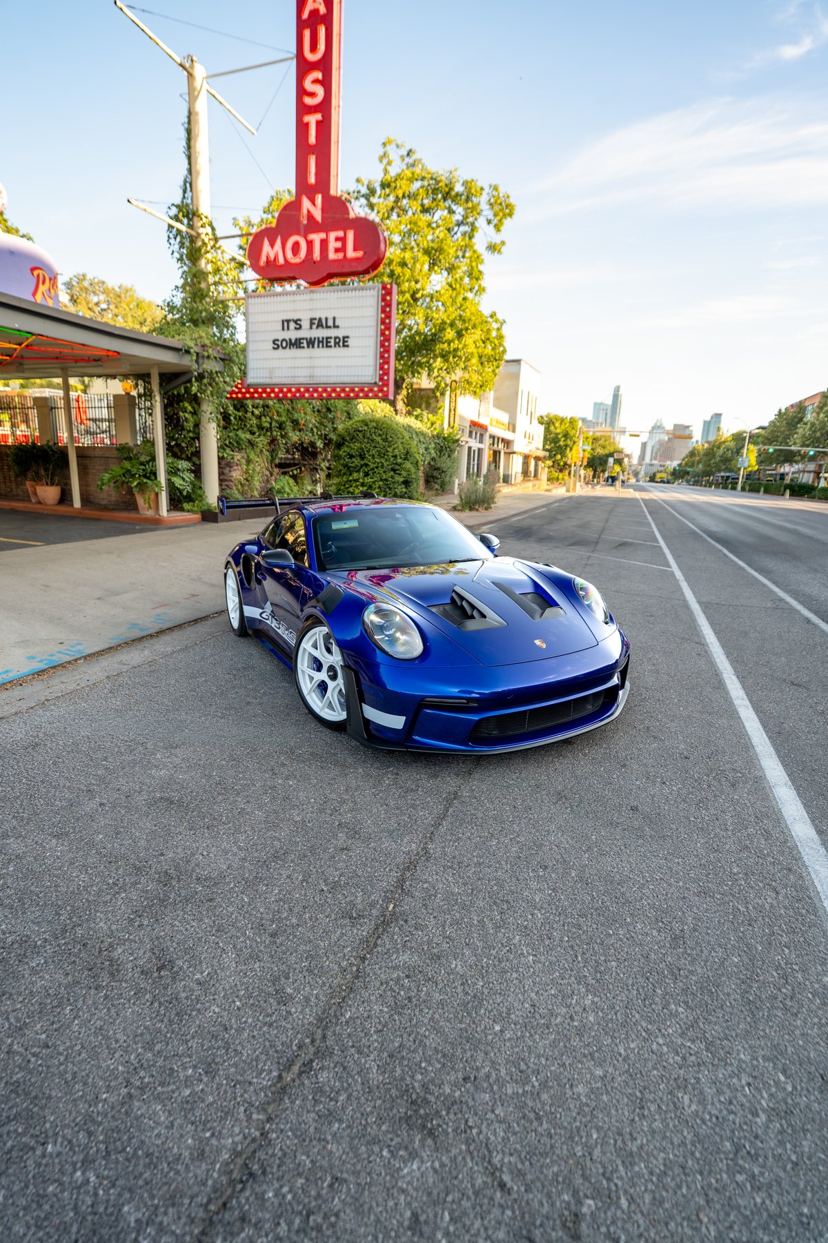 2025 Porsche 911 GT3 RS in blue, with white multi-spoke rims and carbon fiber trim.