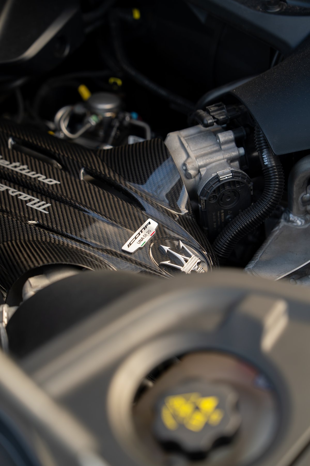 Maserati MC20 Icona engine bay features carbon fiber trim and the Trident emblem.