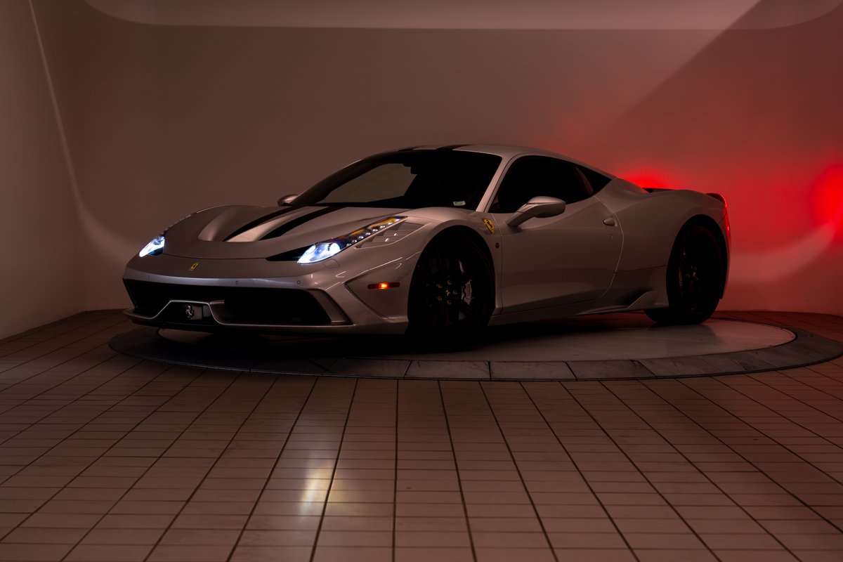 2015 Ferrari 458 Speciale in silver with black racing stripes and black rims.