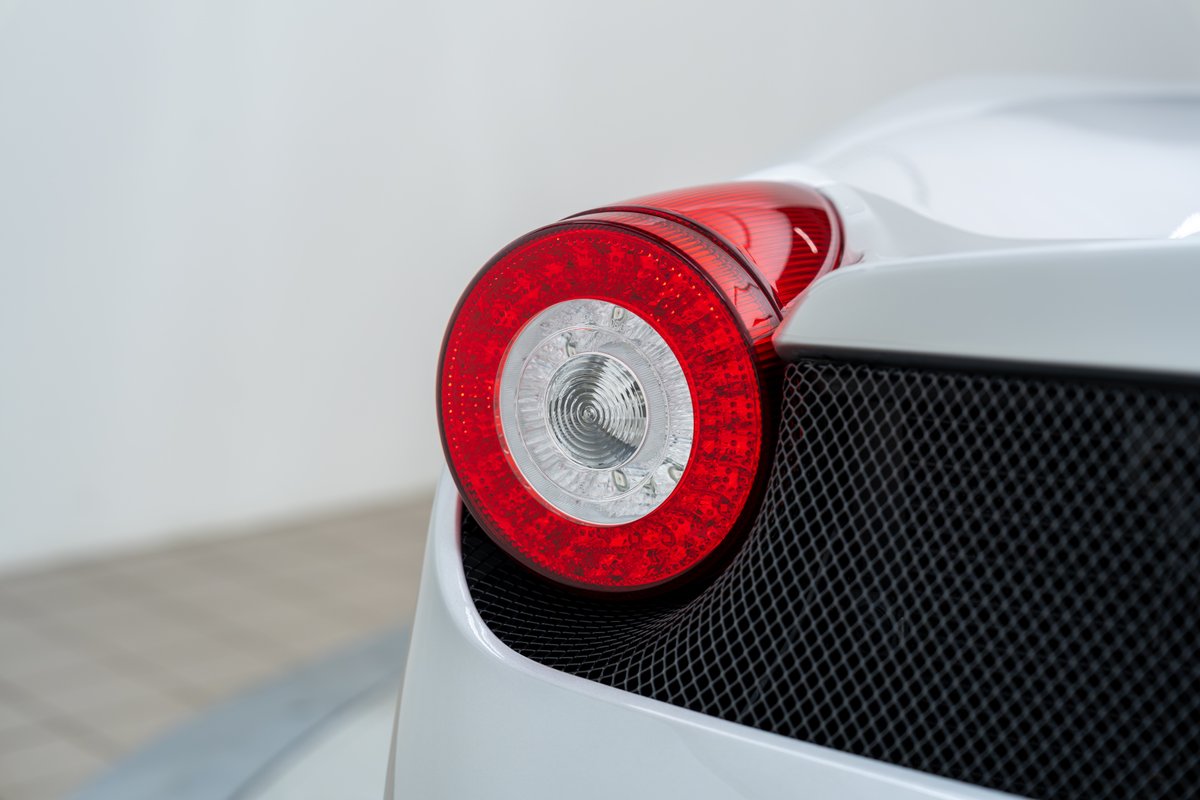 Close up of the circular red LED taillight on a white 2015 Ferrari 458 Speciale.