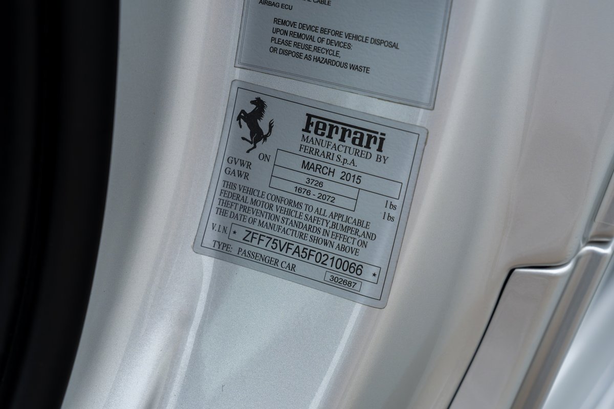 Close-up of a silver 2015 Ferrari 458 Speciale VIN sticker on doorjamb.