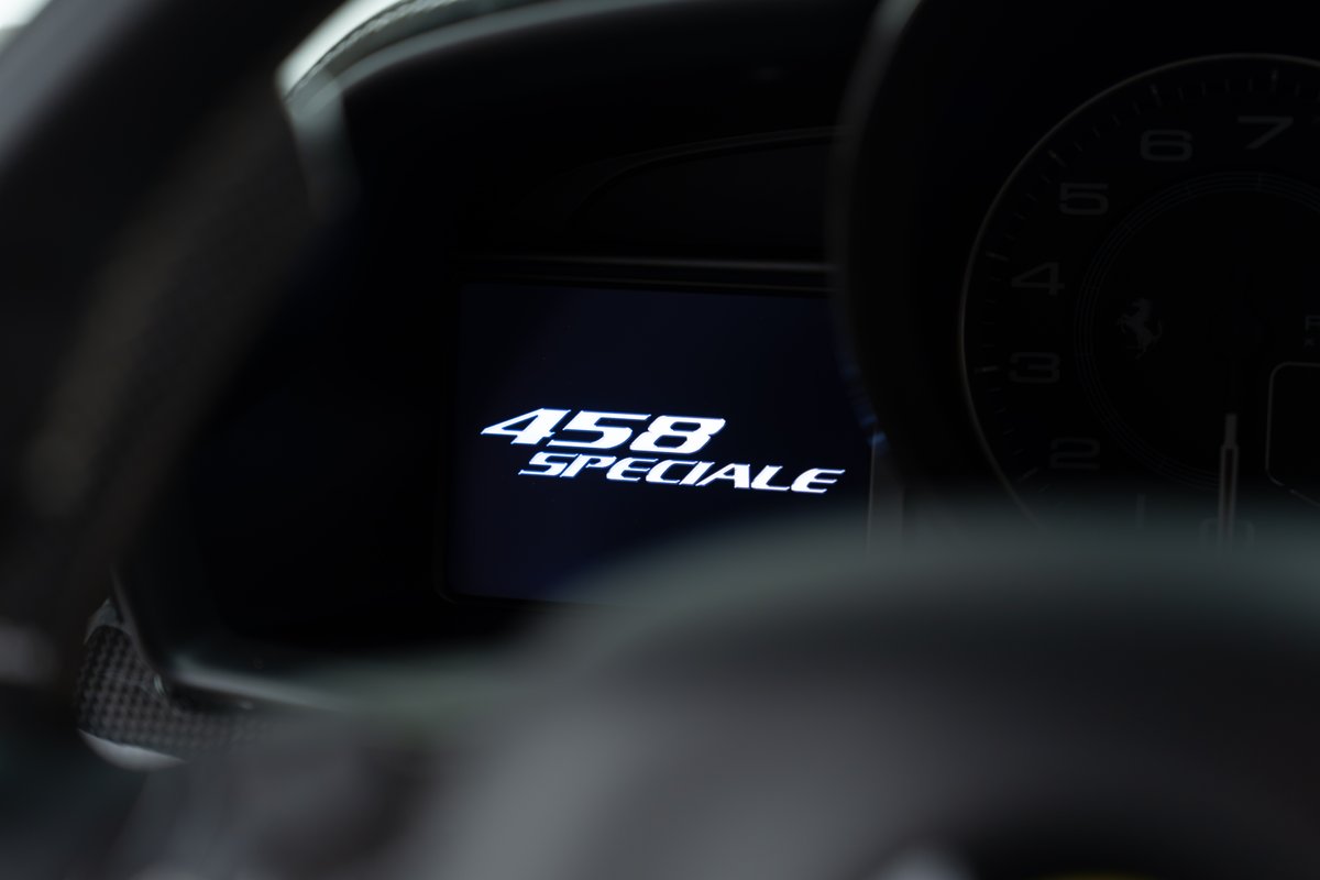 Dashboard display of a 2015 Ferrari 458 Speciale showing the model name in white font.