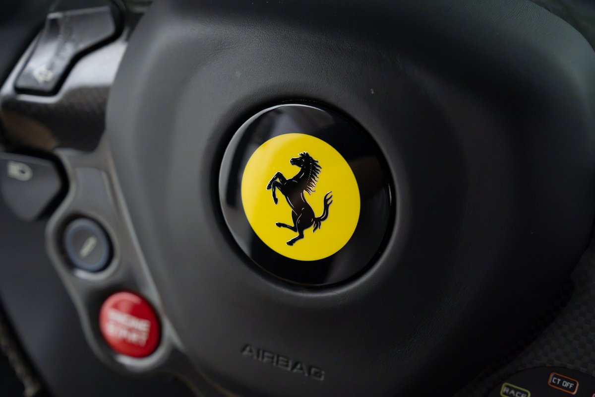 Ferrari 458 Speciale steering wheel with Prancing Horse logo, carbon fiber trim, and red Engine Start button.
