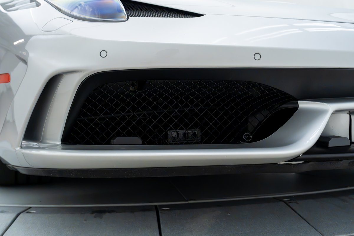 2015 Ferrari 458 Speciale front bumper with black mesh grille and silver trim.