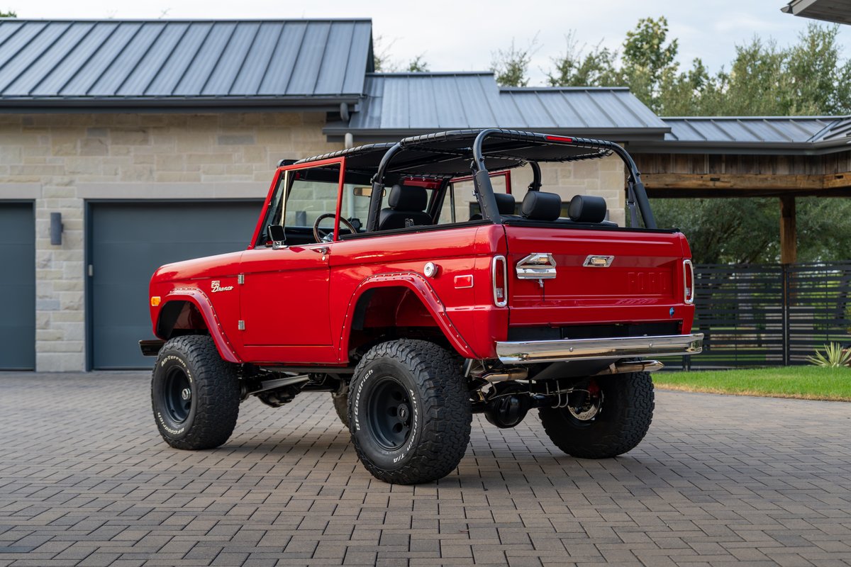 Red 1966 Ford Bronco by Atlas Broncos with black roll cage and BFGoodrich tires on black rims.