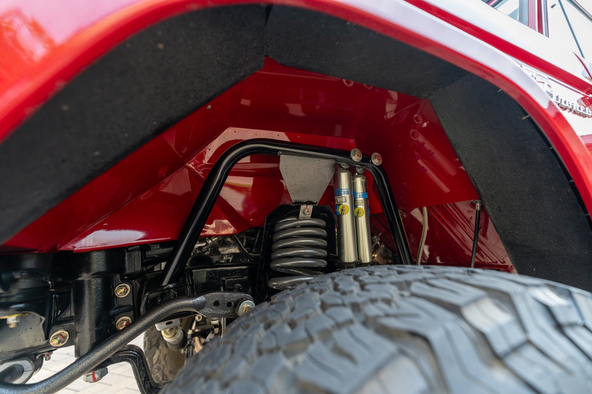 1966 Ford Bronco's red fender well with Bilstein shocks and coilover suspension.