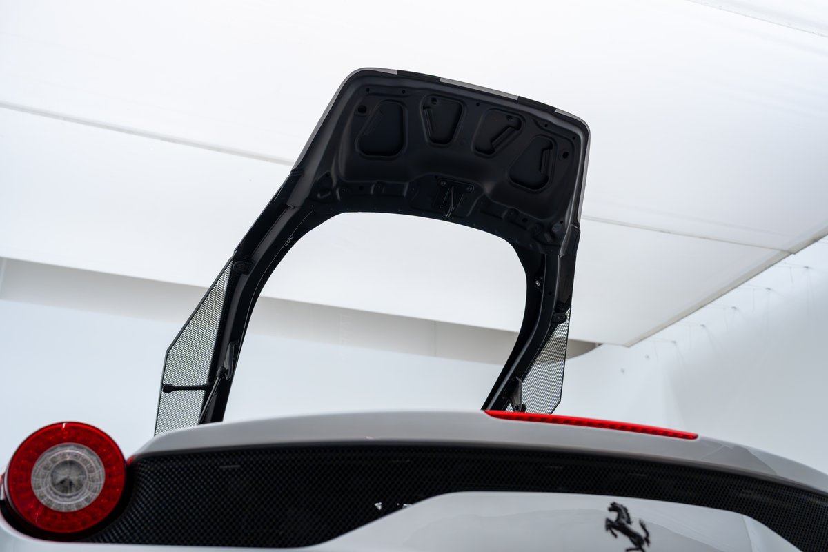 2015 Ferrari 458 Speciale engine cover open, showing mesh intake vents and taillight detail.