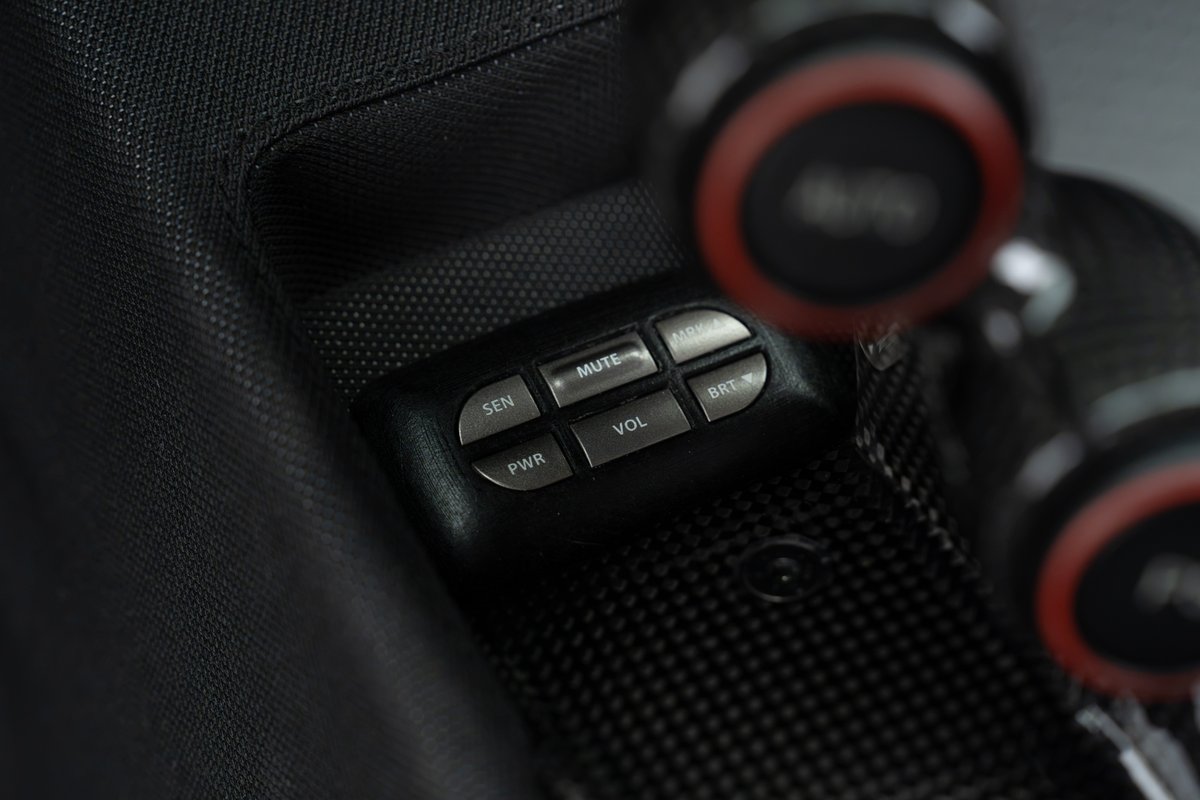 Close-up of the 2015 Ferrari 458 Speciale's carbon fiber interior trim, showing media controls.