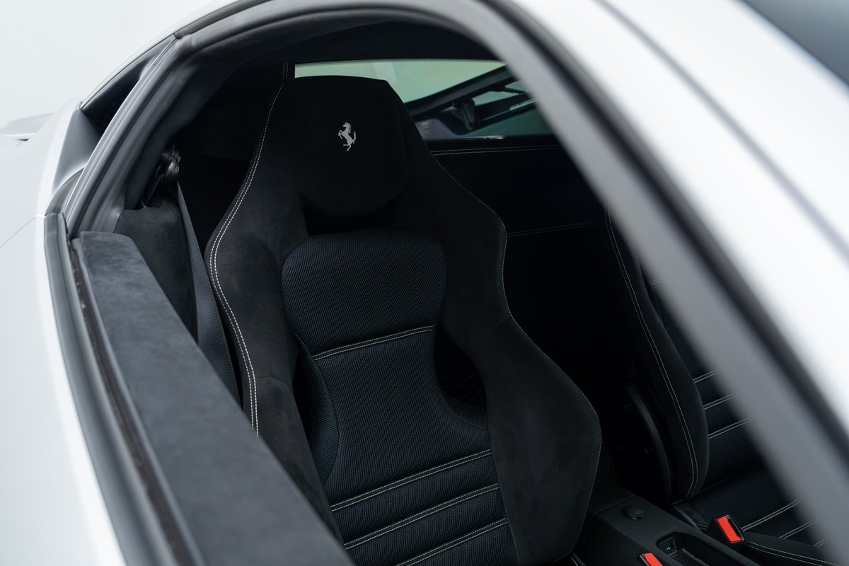 Black Alcantara bucket seats with white stitching and Ferrari logo in a 2015 Ferrari 458 Speciale.
