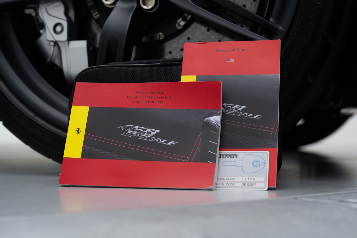 2015 Ferrari 458 Speciale owner's manual and reference guide beside the tire.