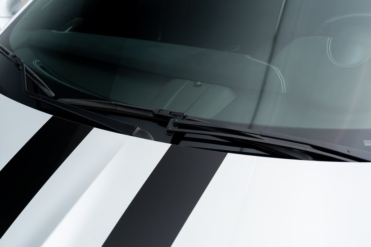 2015 Ferrari 458 Speciale in white with black racing stripes and dual windshield wipers.