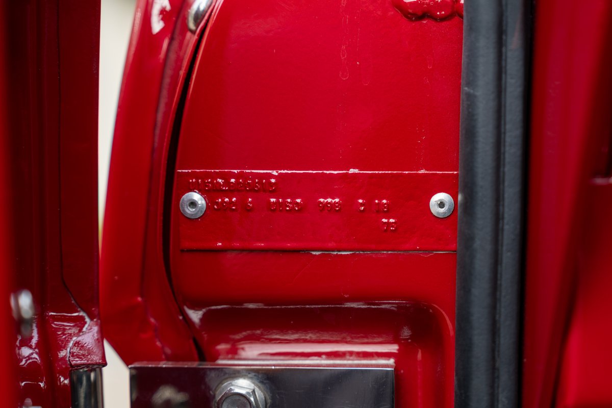 Close-up of a red 1966 Ford Bronco door tag with VIN and trim information.