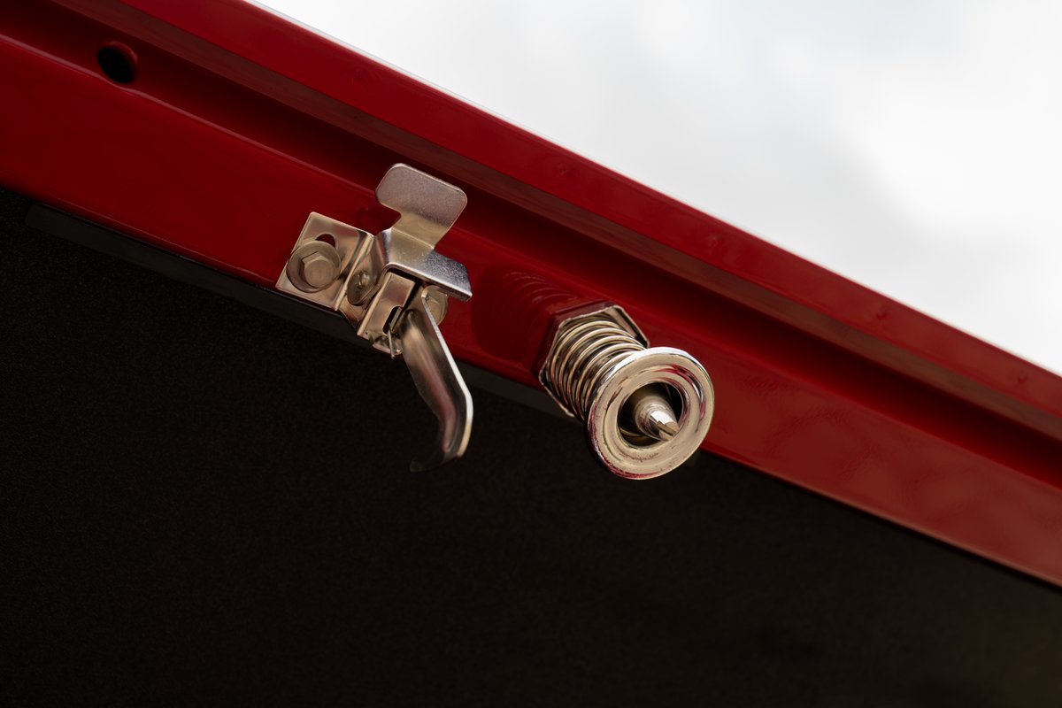 1966 Ford Bronco hood latch, red exterior paint, polished chrome hardware.