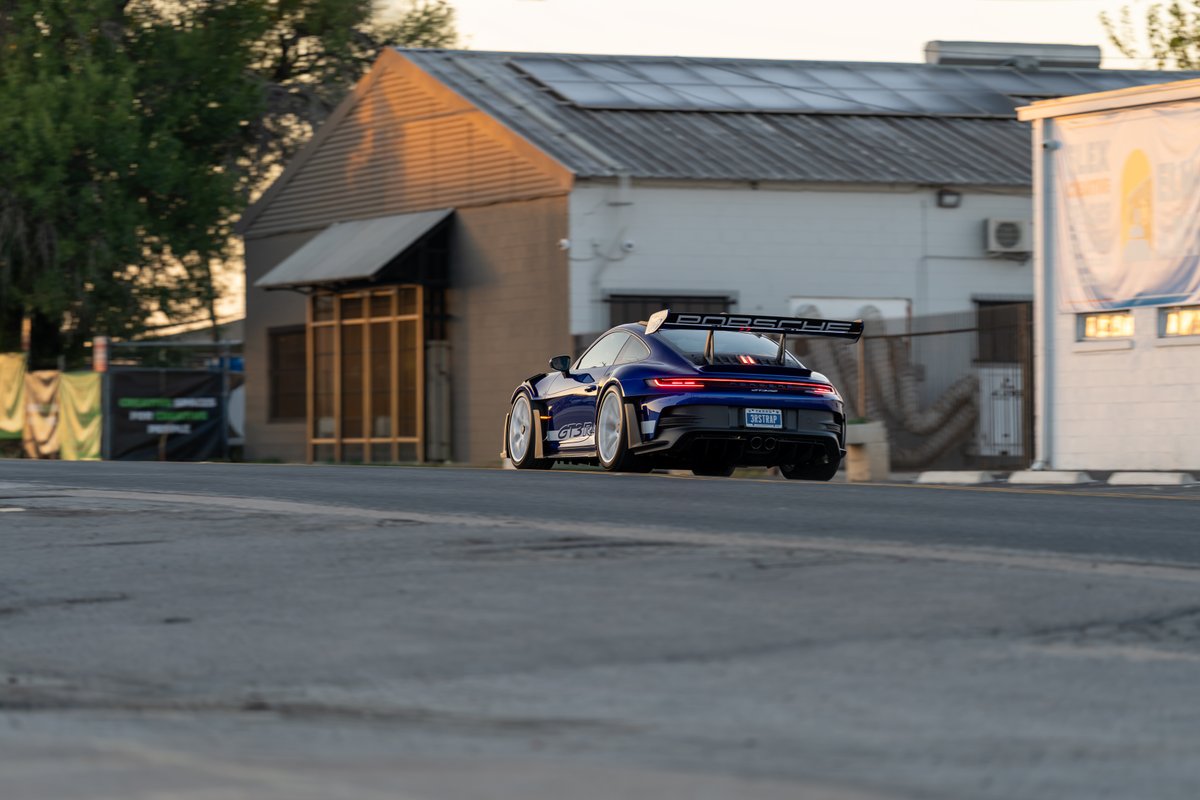 Blue 2025 Porsche 911 GT3 RS with rear wing, side decal, and silver rims.