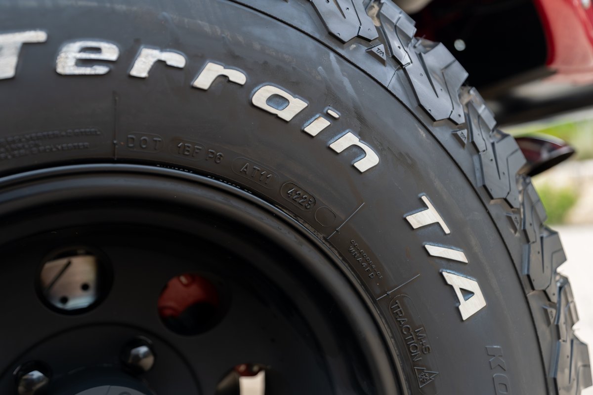 BFGoodrich All-Terrain T/A tires on a black rim of a red 1966 Ford Bronco by Atlas Broncos.