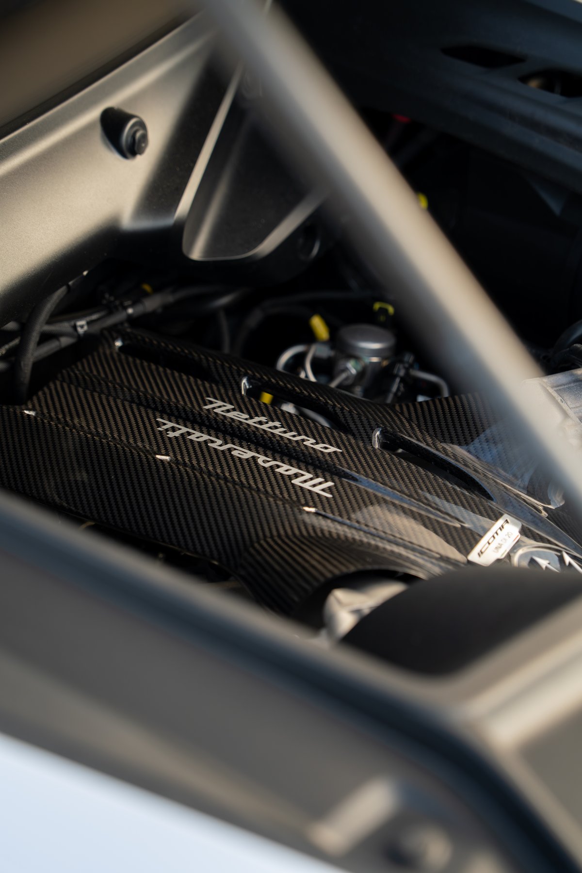 Maserati MC20 Icona engine bay with carbon fiber Nettuno engine cover and silver trim.
