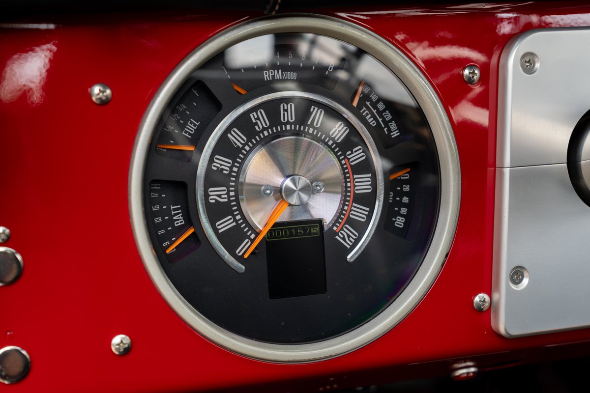Close-up of a custom 1966 Ford Bronco dashboard, featuring a tachometer, fuel, battery, and temp gauges.