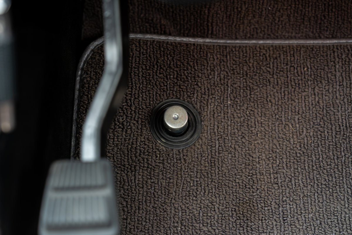 1966 Ford Bronco interior: brown carpet, rubber floor mat, clutch pedal.