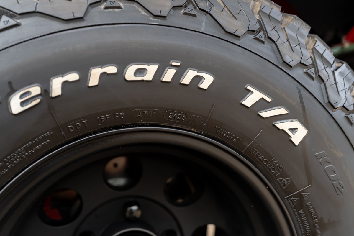 Close up of a BFGoodrich All-Terrain T/A KO2 tire on a black rim, on a 1966 Ford Bronco.