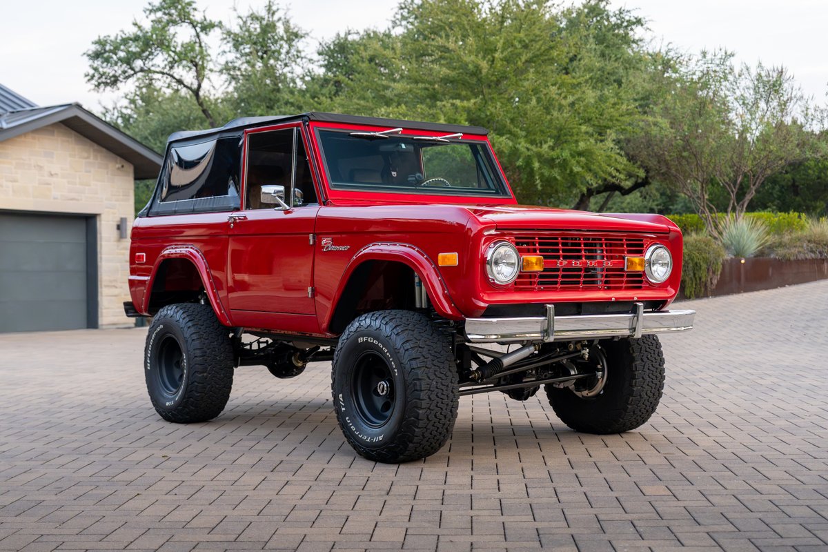 Red 1966 Ford Bronco by Atlas Broncos with BFGoodrich All-Terrain tires on black rims.