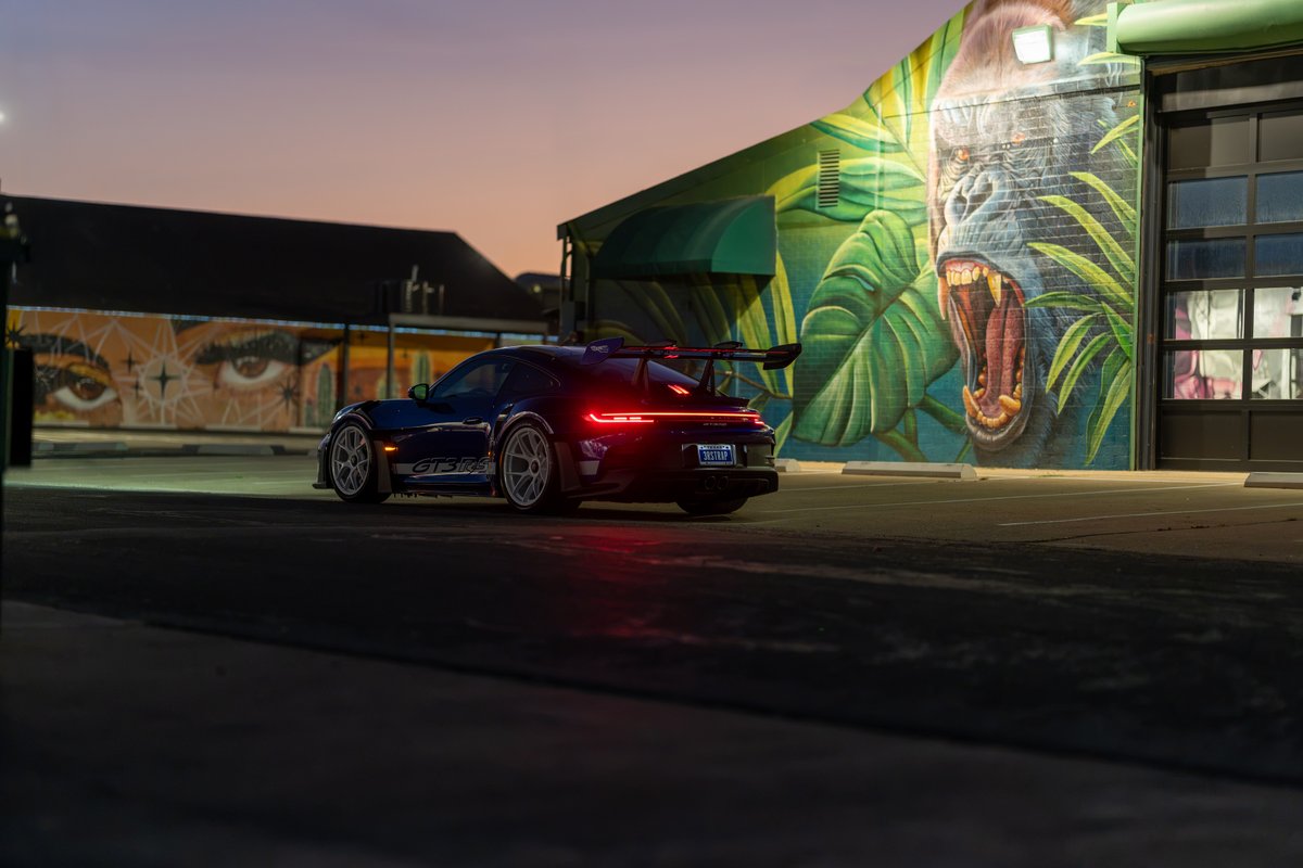 Blue 2025 Porsche 911 GT3 RS with grey center-lock rims, GT3 RS livery, and large rear wing.