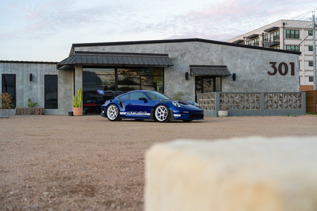A blue 2025 Porsche 911 GT3 RS with white multi-spoke rims and white side livery.