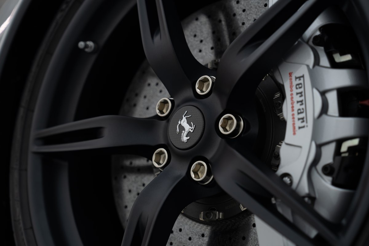 Black Ferrari 458 Speciale wheel with yellow brake calipers and carbon ceramic rotors.