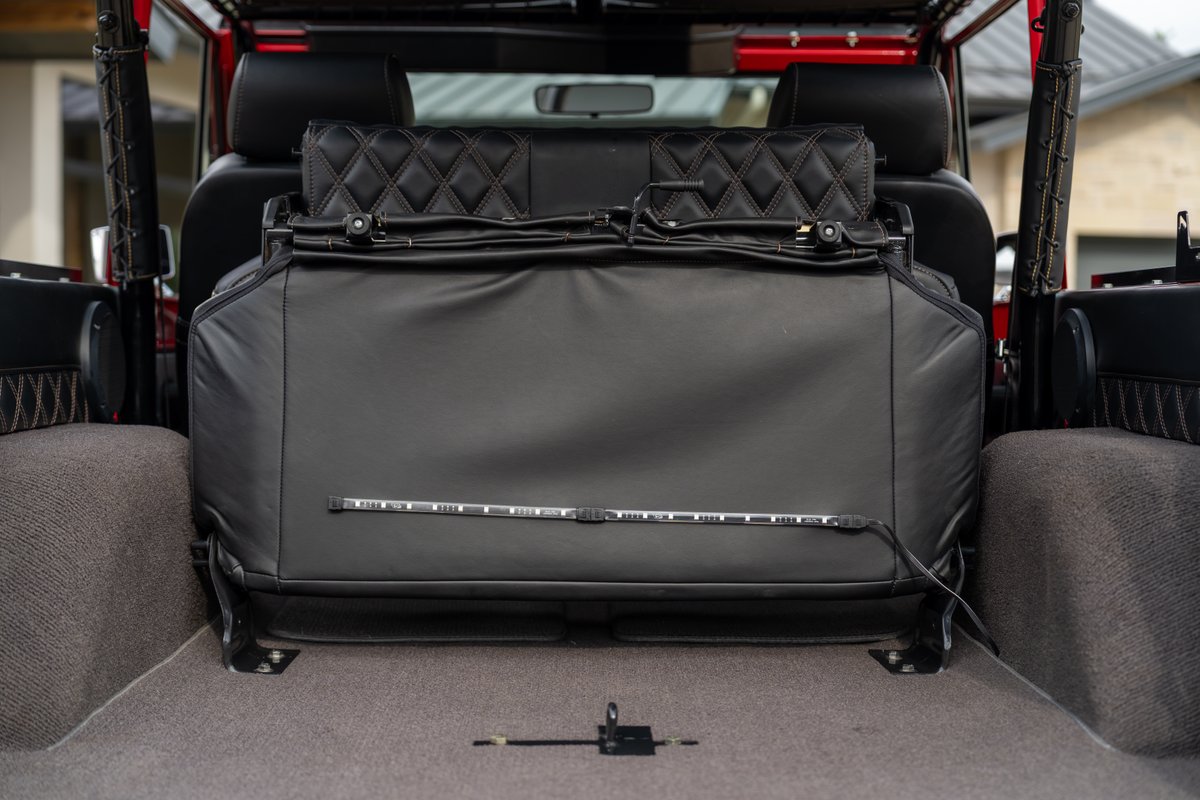 1966 Ford Bronco interior rear seats with diamond-stitched black leather and integrated LED lighting.