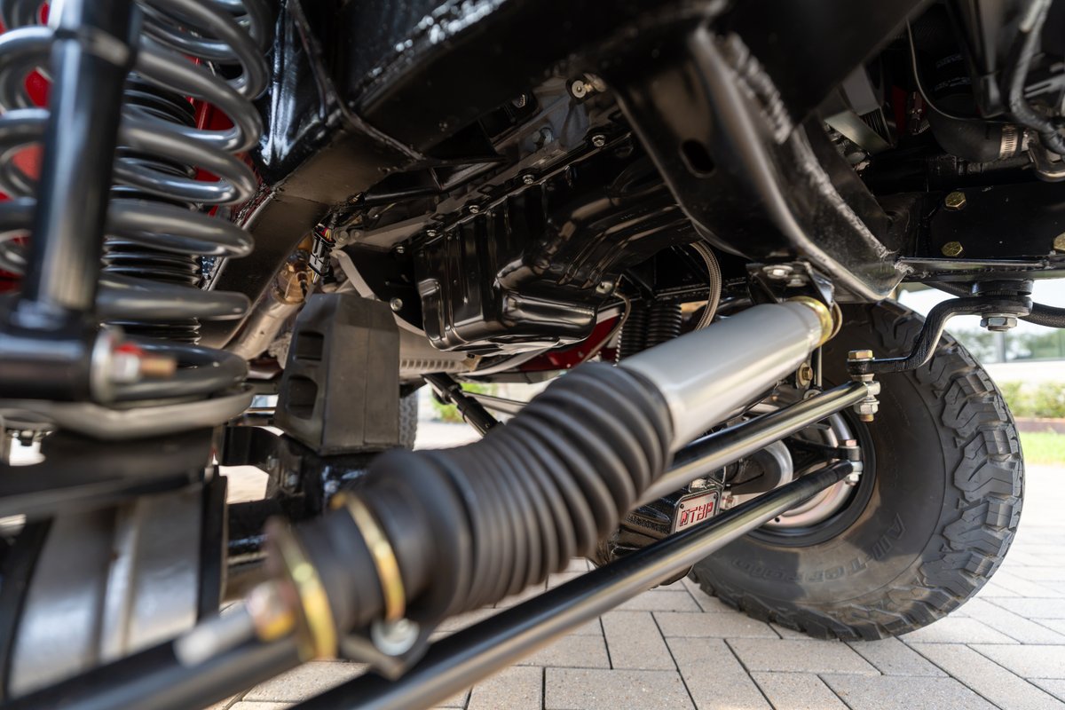 Close-up of a custom 1966 Ford Bronco suspension with heavy-duty shocks and steering components.