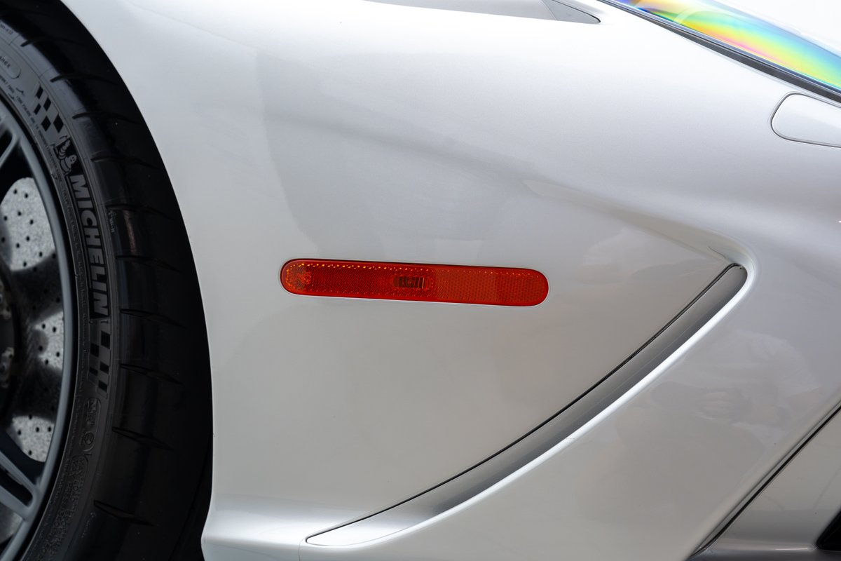 White 2015 Ferrari 458 Speciale fender with orange marker light and Michelin tire.