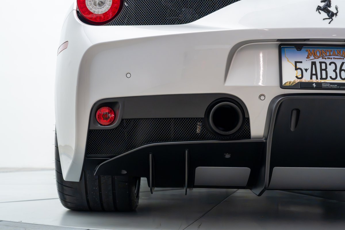 Rear view of a white 2015 Ferrari 458 Speciale showing its black diffuser, exhaust, and taillight.