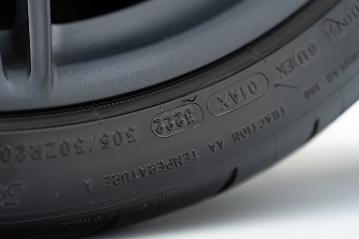 Closeup of a 2015 Ferrari 458 Speciale tire with markings: 305/30ZR20, 01AX, and date code 3222.