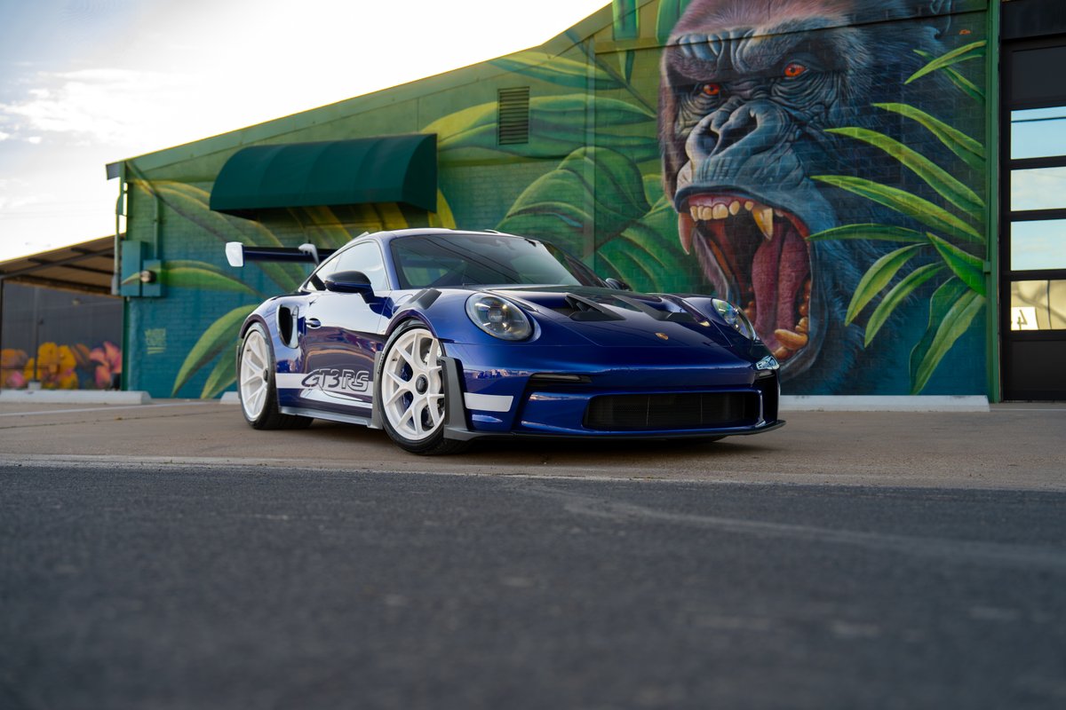 2025 Porsche 911 GT3 RS in blue with white livery and white racing rims.