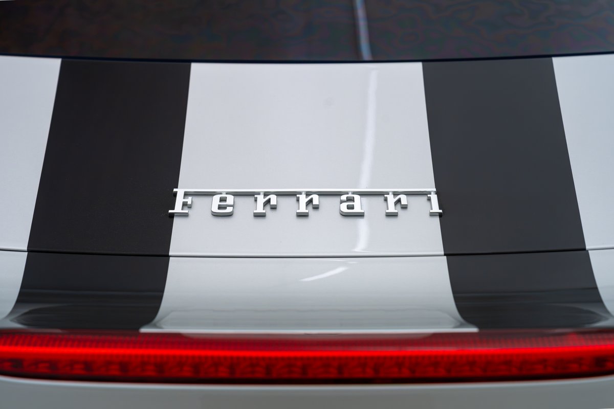 2015 Ferrari 458 Speciale rear with black racing stripes and chrome trim.