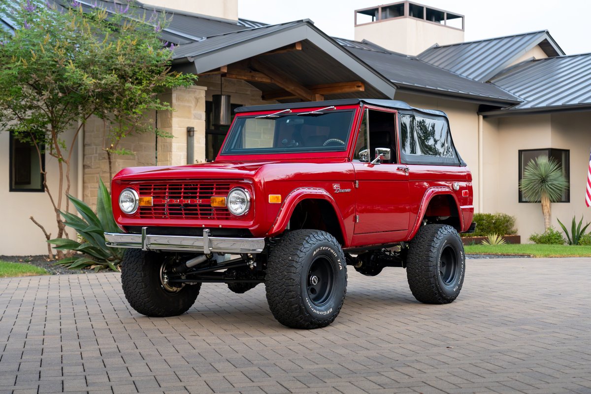 Red 1966 Ford Bronco with black rims, BFGoodrich All-Terrain tires.