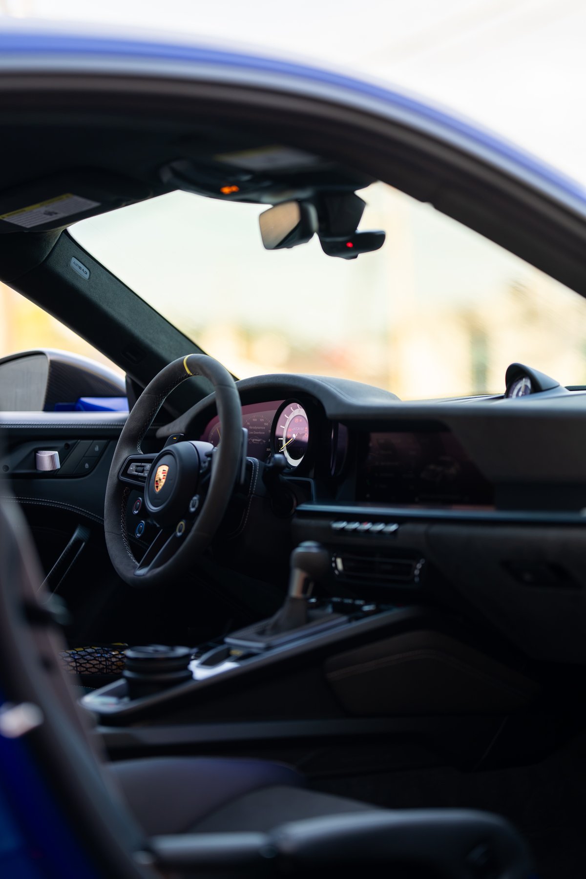 2025 Porsche 911 GT3 RS interior view showing the steering wheel and dashboard.