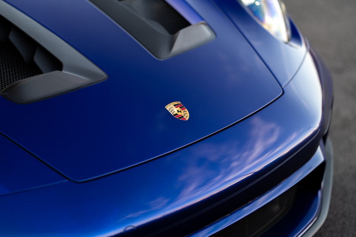 Blue 2025 Porsche 911 GT3 RS hood with Porsche crest and front bumper detail.