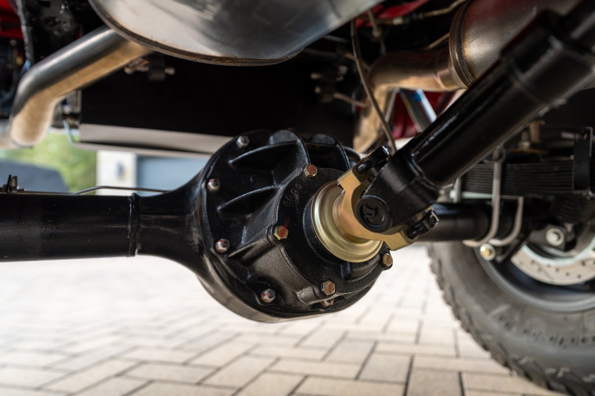 Close-up of a 1966 Ford Bronco rear axle, driveshaft, and exhaust.