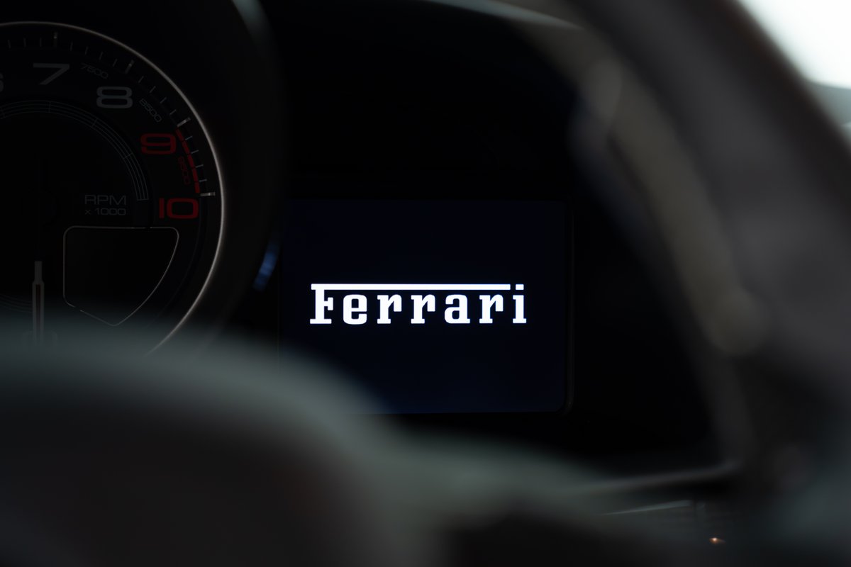 Digital dashboard of a 2015 Ferrari 458 Speciale displaying the Ferrari logo.