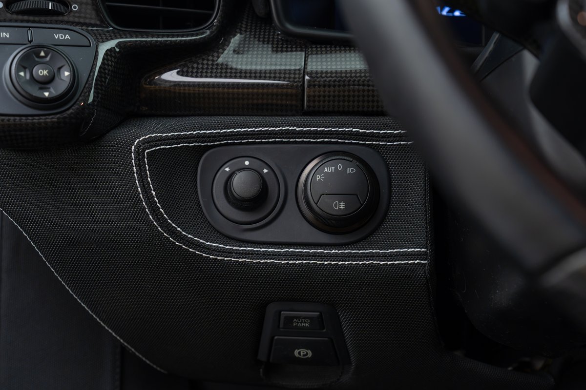 2015 Ferrari 458 Speciale interior: carbon fiber trim, textured fabric, headlight and mirror controls.