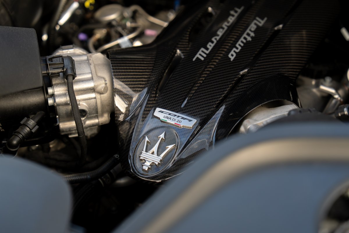 Maserati MC20 Icona engine with carbon fiber trim and Trident emblem.