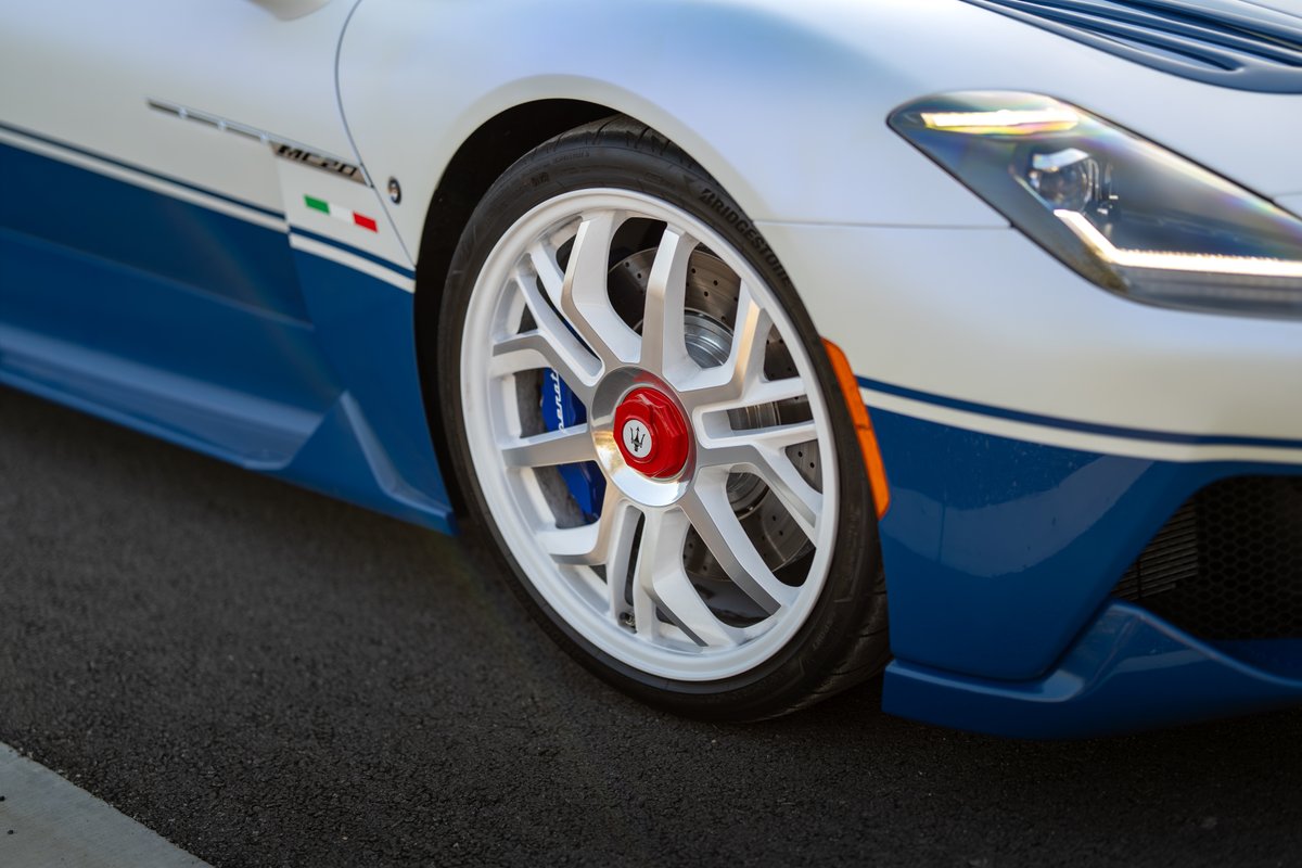 Maserati MC20 Icona in white with blue livery, featuring white rims and blue brake calipers.