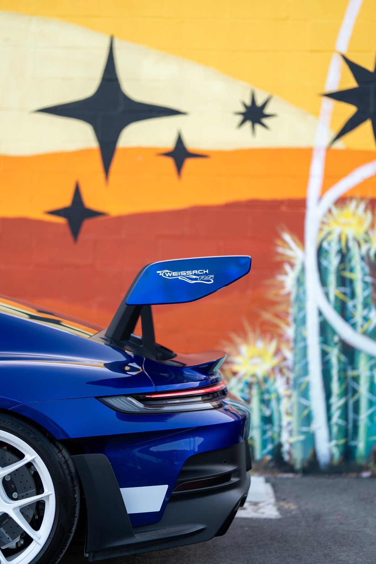 Blue 2025 Porsche 911 GT3 RS with Weissach RS livery on rear wing.