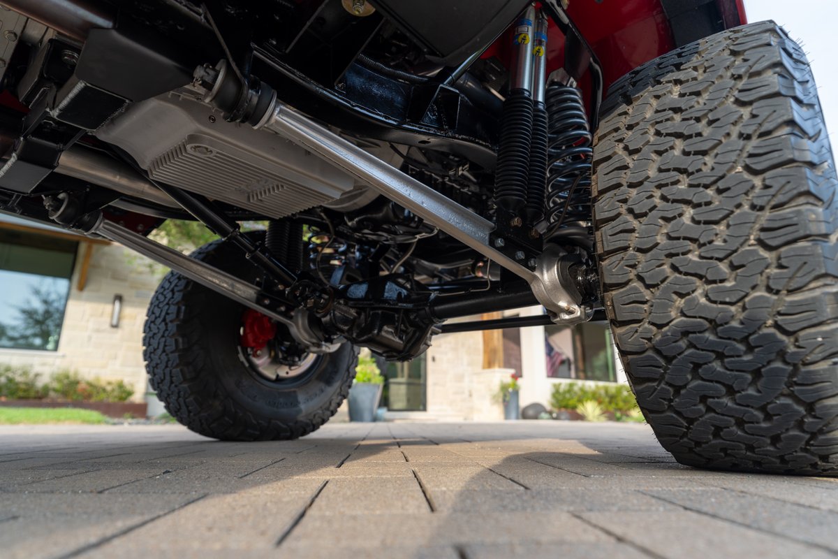 1966 Ford Bronco undercarriage showing suspension, heavy-duty axles, and large off-road tires.