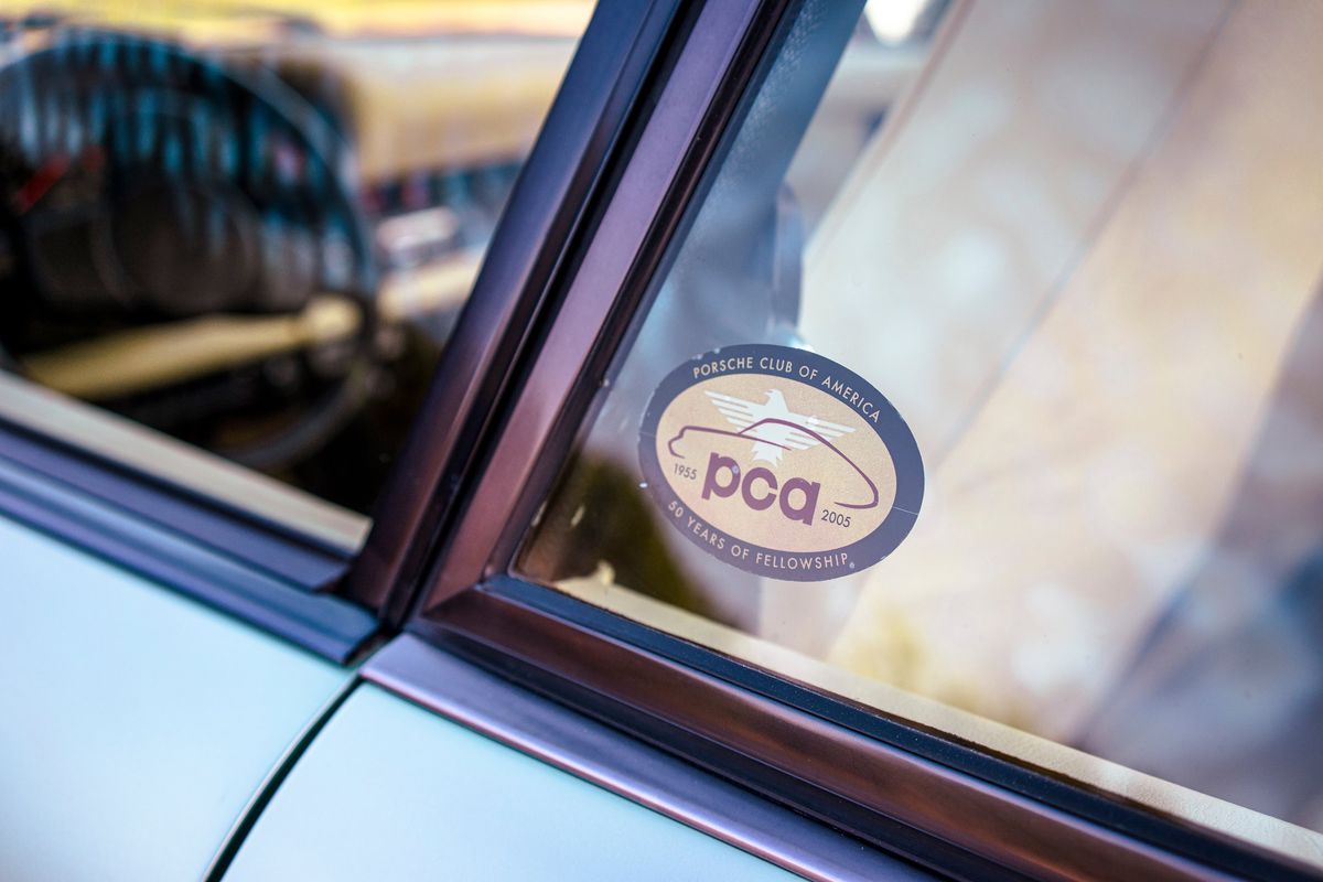 1976 Porsche 930 in Ice Metallic Green, showing PCA 50 Years of Fellowship (1955-2005) sticker on its side glass.