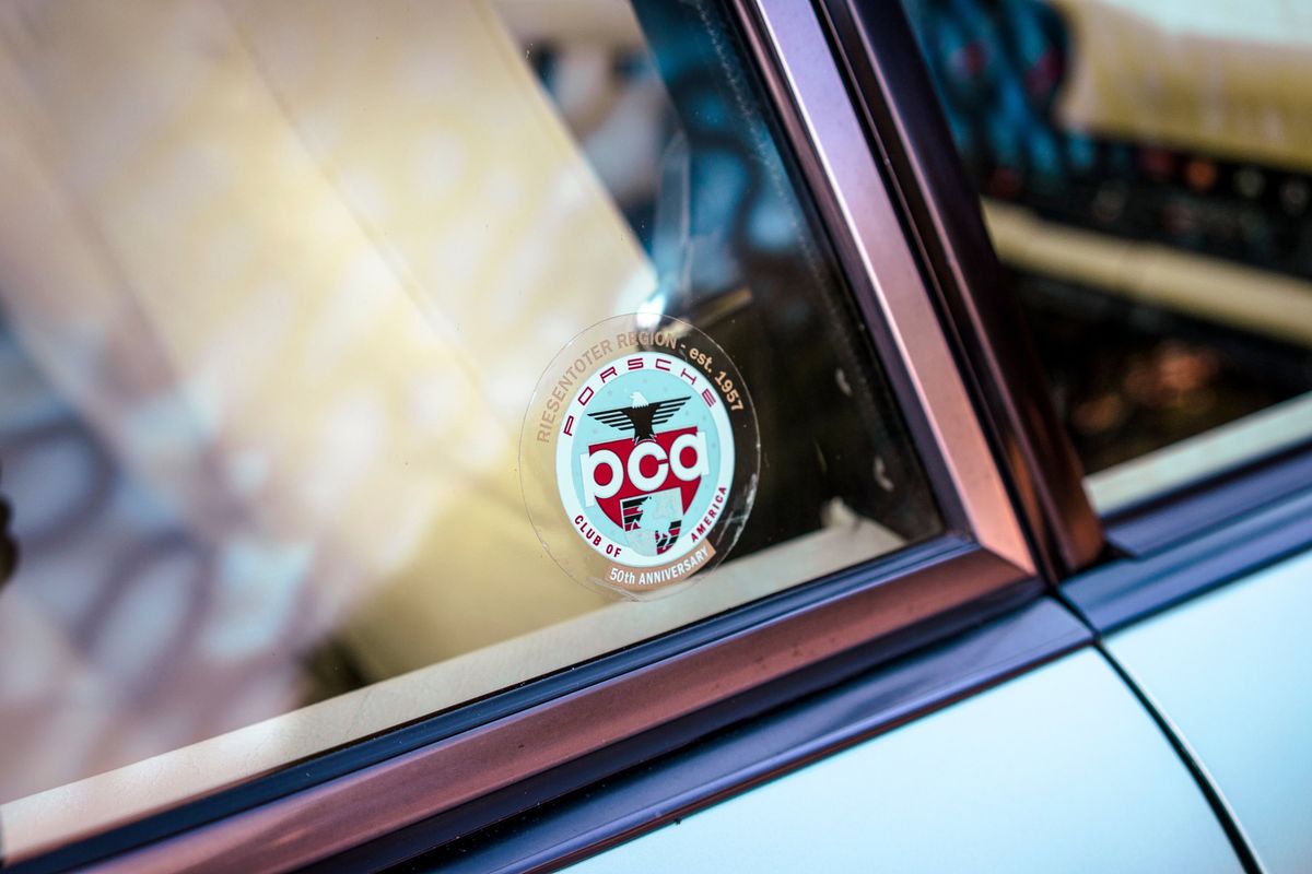 1976 Ice Metallic Green Porsche 930 side window with Riesentoter PCA 50th Anniversary decal and bronze trim.