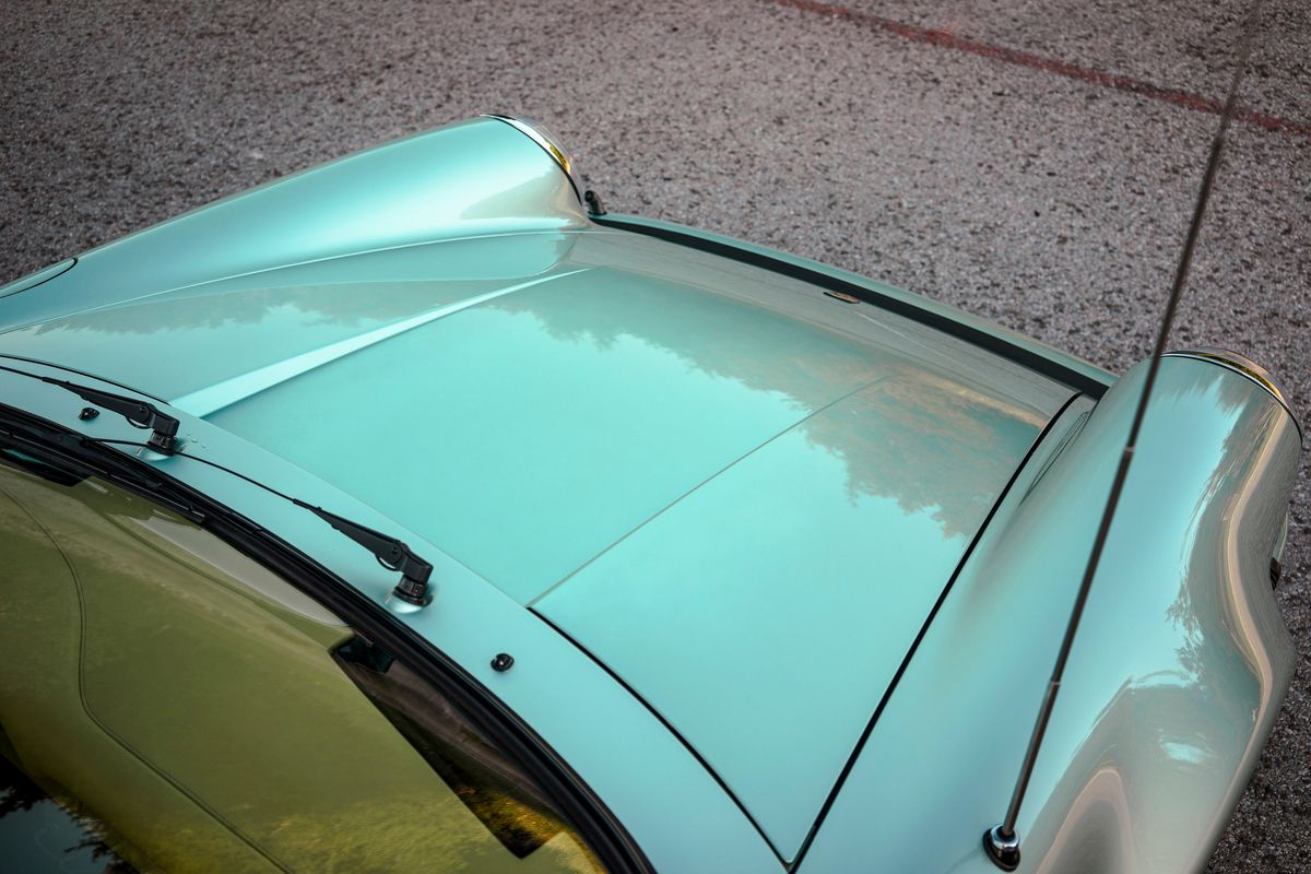 Reflective Ice Metallic Green 1976 Porsche 930, highlighting the hood, chrome headlight bezel, and windshield wipers.