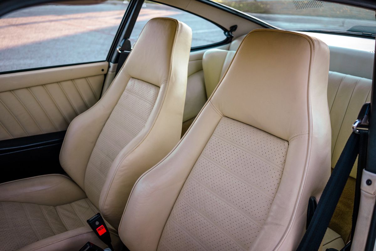 Pristine 1976 Porsche 930 interior: Parchment perforated leather sport seats, matching door panels, and rear trim.